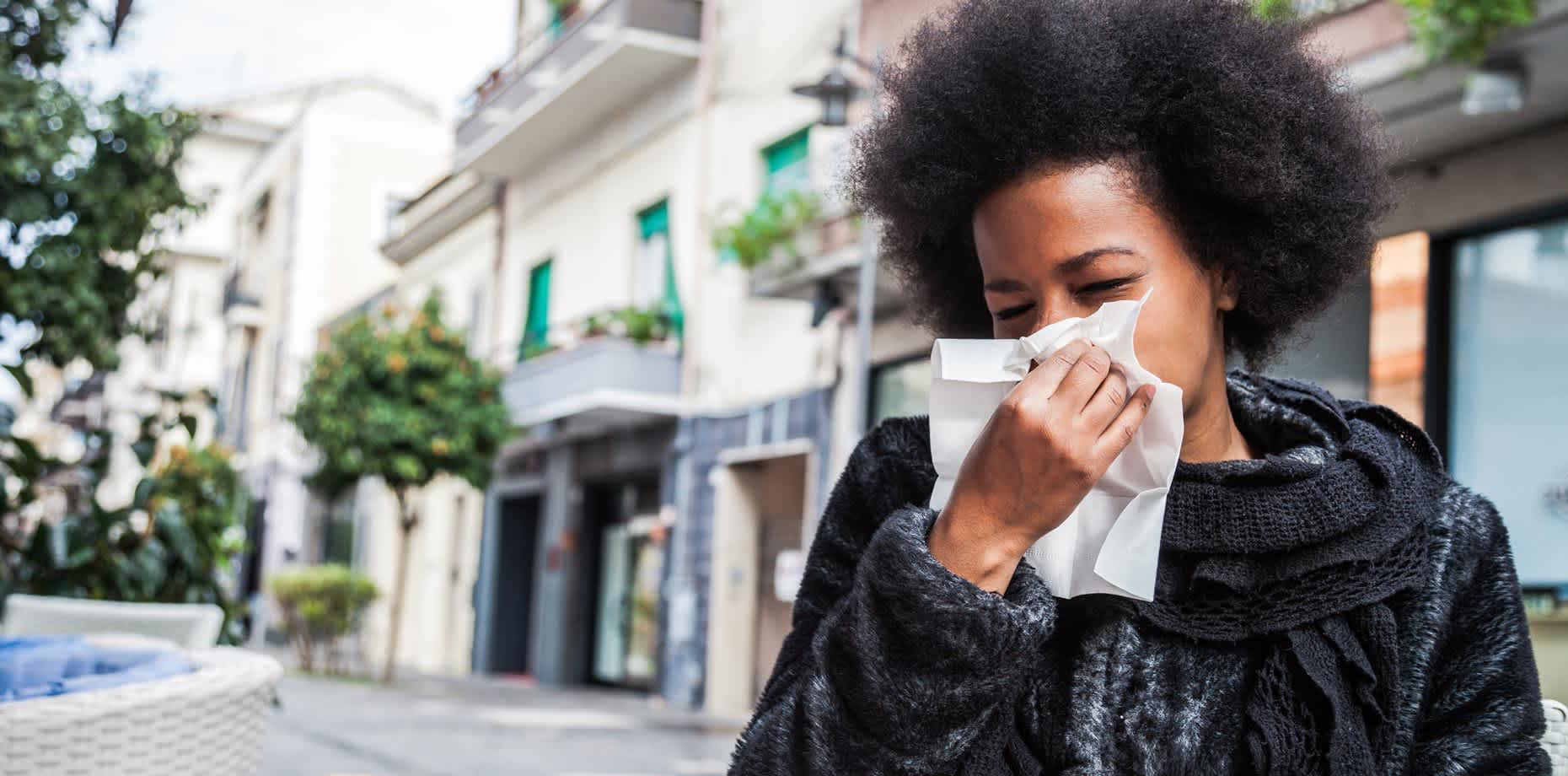 Woman blowing her nose while experiencing almond allergy symptoms