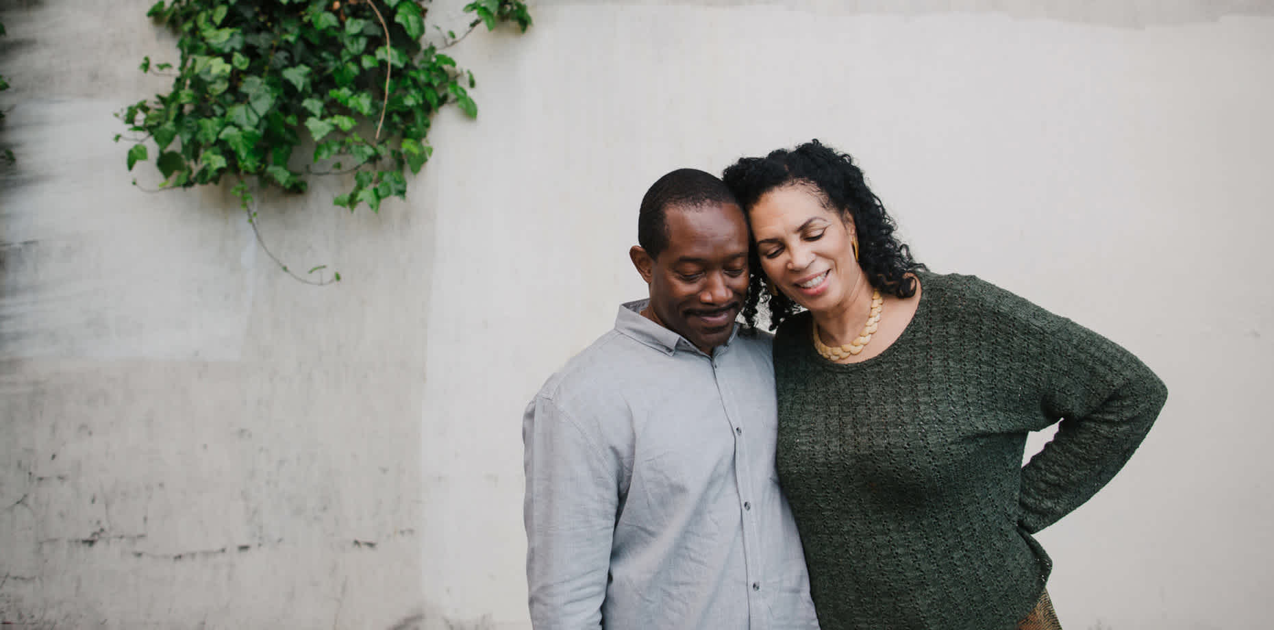 Man in blue shirt and woman in green shirt hugging side by side to discuss colon cancer statistics