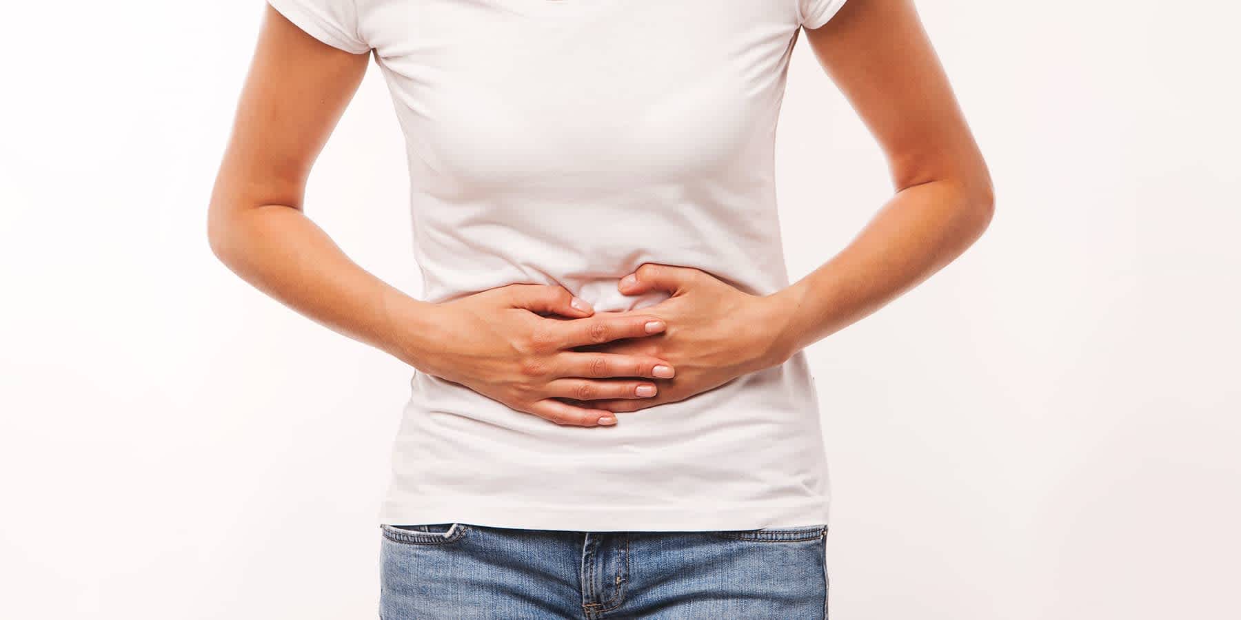 Woman holding her hands over her abdomen while experiencing symptoms of gonorrhea in women