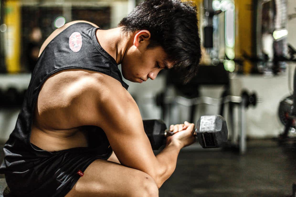 Man lifting weight at gym and benefitting from increased testosterone