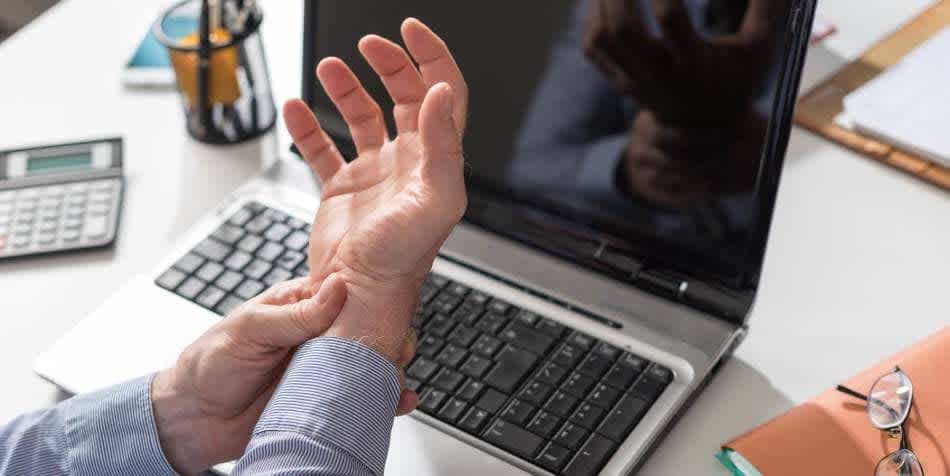 Man experiencing joint pain holding his wrist with his fingers