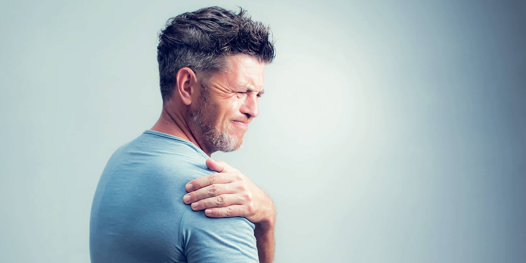 Man holding shoulder muscle in pain with possible B12 deficiency