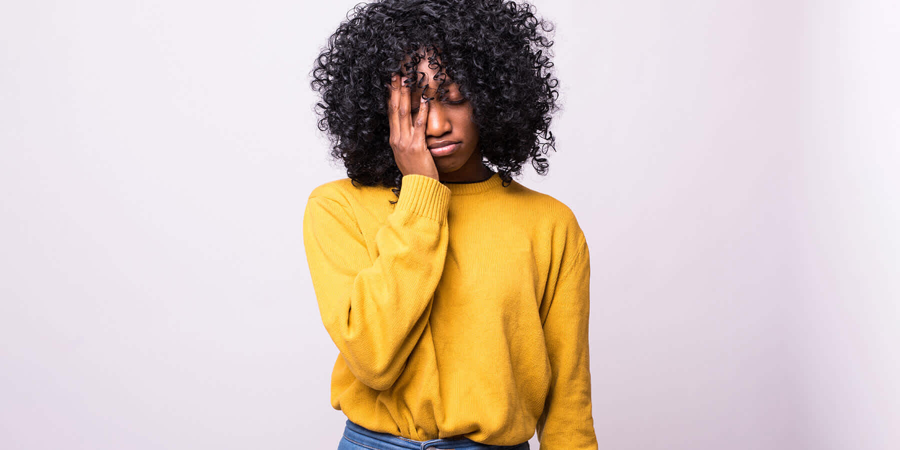 Tired woman with hand on face wondering about vitamin B12 and energy