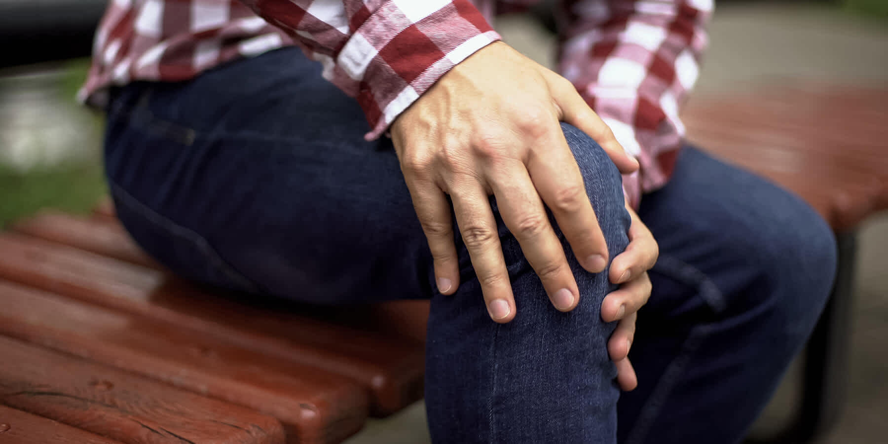 Man holding knee and experiencing long-term effects of Lyme disease 