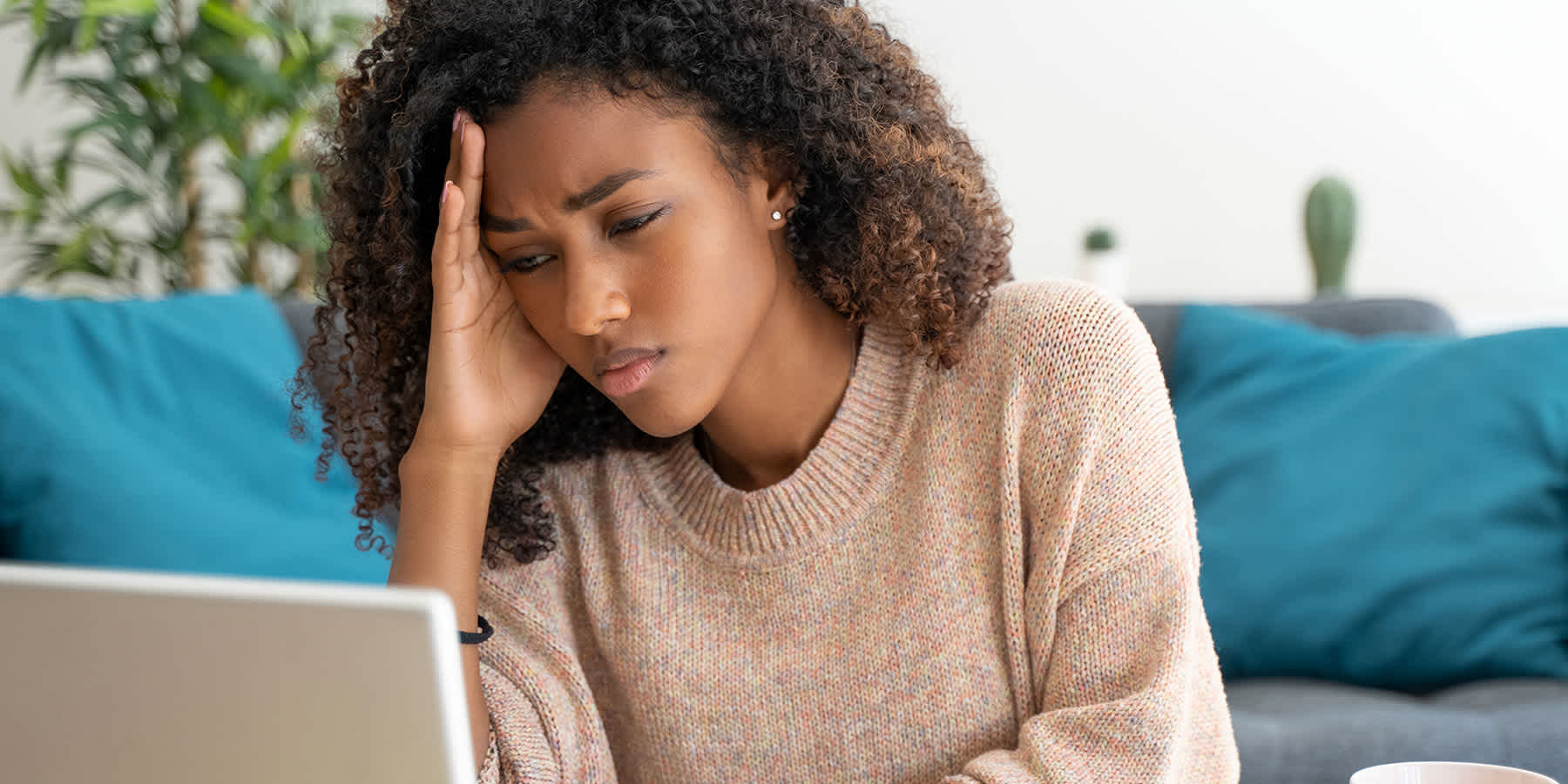 Distressed young woman using laptop to look up what happens if BV goes untreated