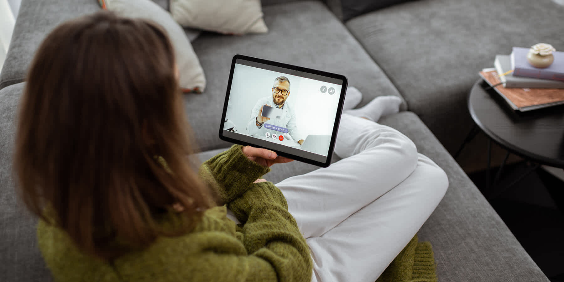 Woman holding a tablet and discussing what remote patient monitoring is with a healthcare provider