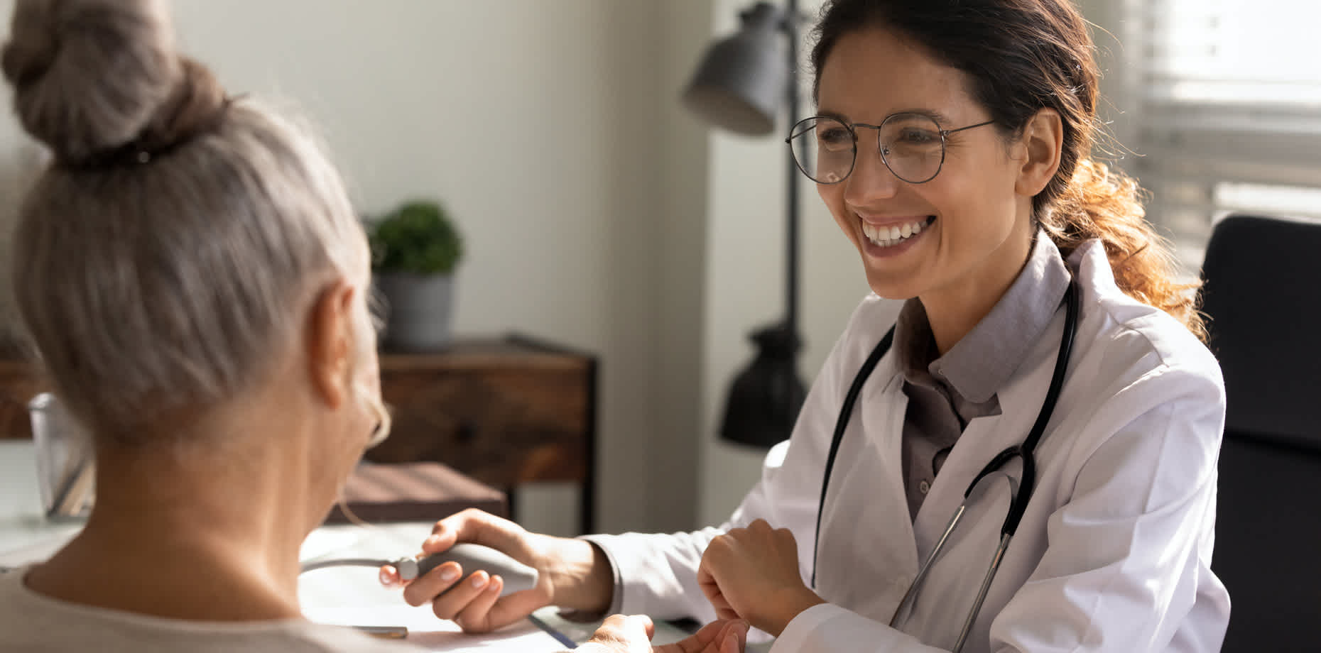 Healthcare provider holding blood pressure device and speaking with patient about omega-3 fatty acids