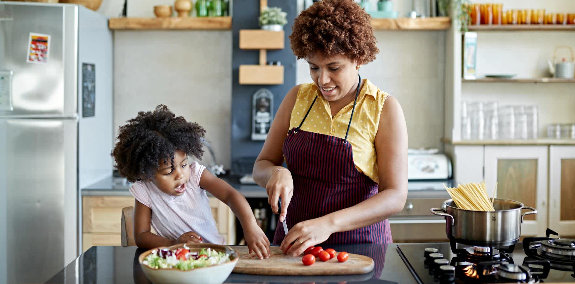 A woman and her child in the kitchen.