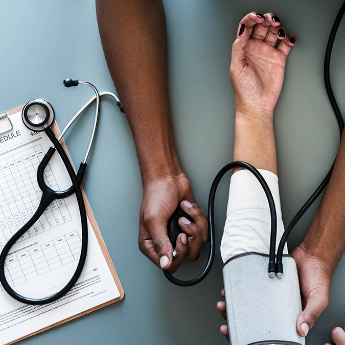 Provider checking someone's blood pressure and Hba1c levels