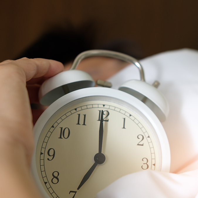 Person holding clock worrying about stress and sleep health