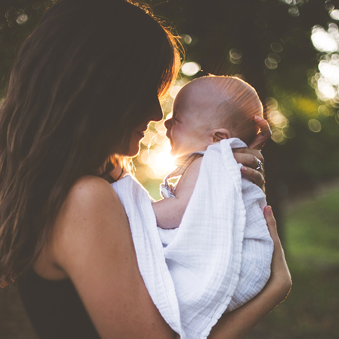 Woman holding baby and thinking about her fertility 